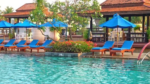 bed pool and umbrella around swimming pool