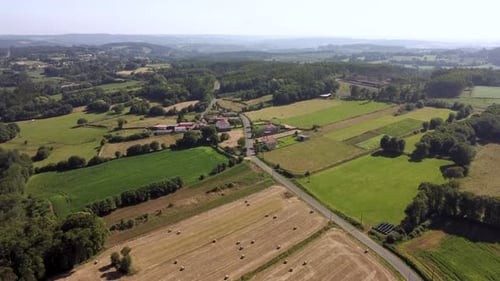 Vastness Of Rural Landscape With Isolated Village Near Farmland During Harvest Season. Aerial Shot