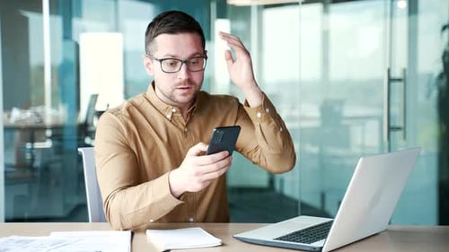 Frustrated Businessman Looking at his Mobile Phone