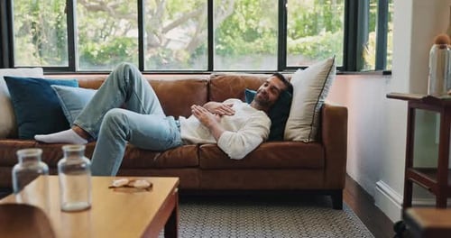 Man, relax and chilling on weekend in home, happy and listening to music in living room