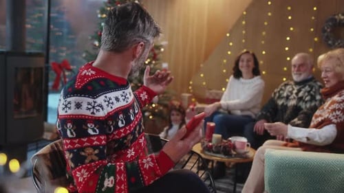 Family Gathers Around Phone at Christmas Celebration
