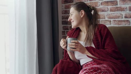 Woman Sitting on Sofa Drinking Coffee