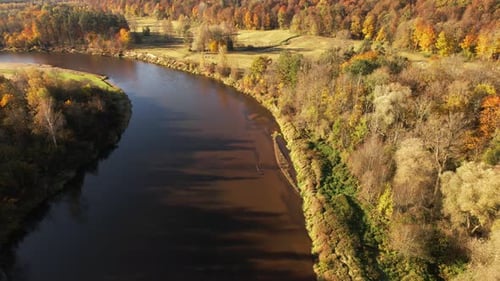 Autumn river landscape with colorful foliage along the banks at midday