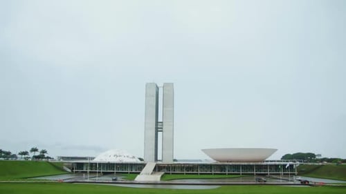 Outside view of Brazilian Congress Building in Brasilia in a Rainy Cloudy Day with green grass Tilt