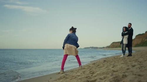 Peaceful family enjoying holiday vacation at ocean coastline with little girl