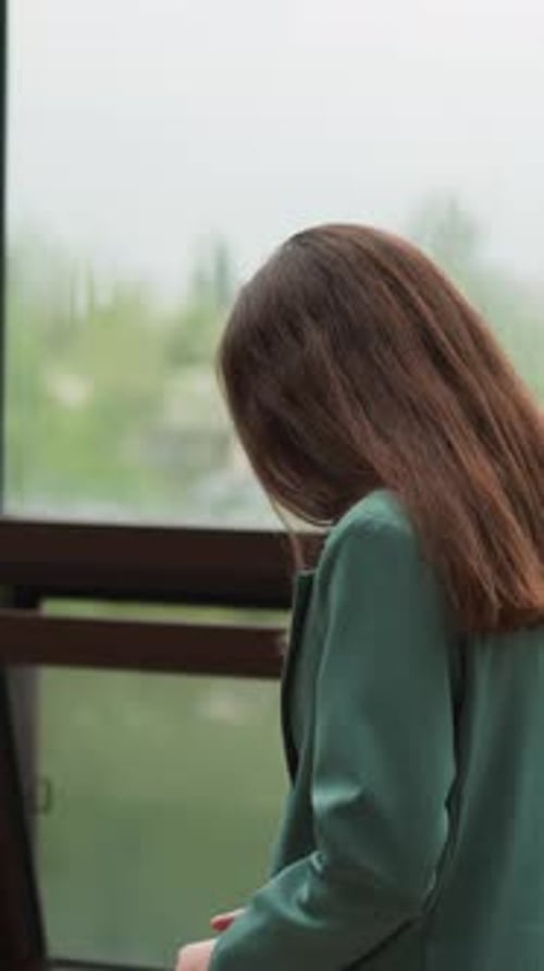 Pensive Businesswoman Walks Along Glass Terrace