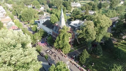 Cinematic high aerial of church along parade route on Independence Day in Lititz, Lancaster County,