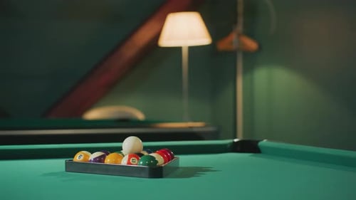 Colorful Billiard Balls Arranged in Triangle Rack on Green Pool Table in Billiard Room