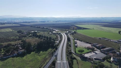 Bird's Eye View of an Asphalt Highway Passing Through Trees Growing in the Countryside and Around