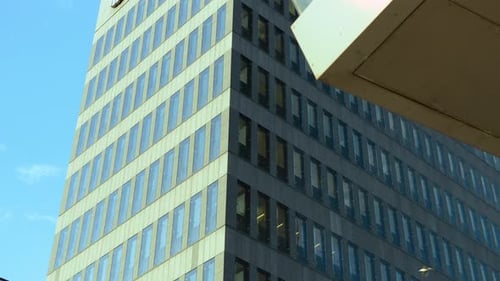 A modern office building with glass windows against a clear blue sky