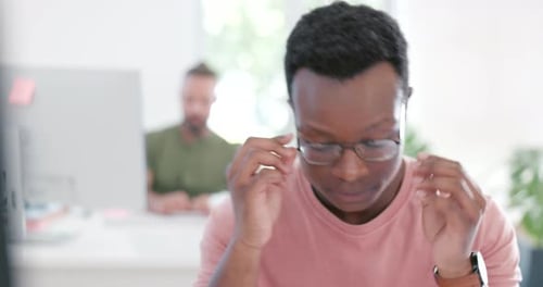 Stressed Man Rubbing Nose Bridge in Office