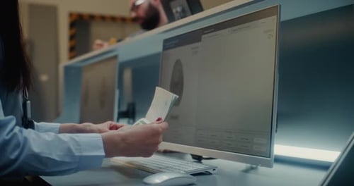 Airport Checkin Counter Airline Agent Checking Documents Ticket and Biometric Data of Passenger