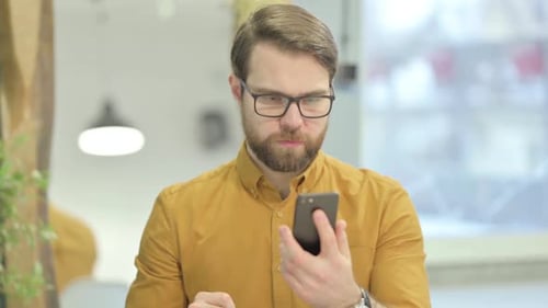 Man With Smartphone Reacts To Good News