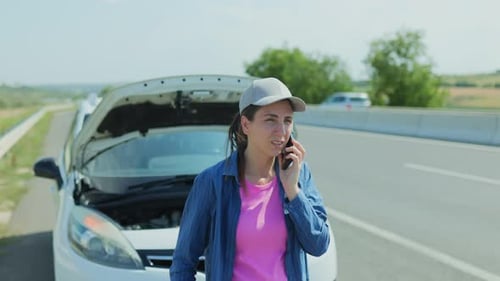 Woman Calling Car Service for Breakdown Assistance on the Highway