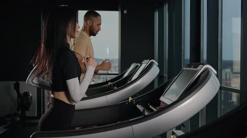 Couple Multiracial Sportsman and Sportswoman Run on Treadmill in Fitness Gym Athletes Woman and Man