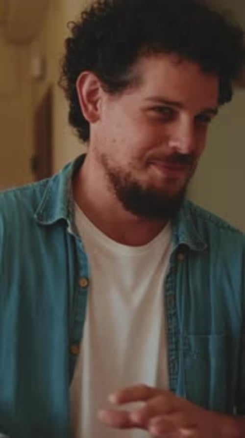 Man Smiling and Talking in Indoor Setting