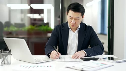 Focused Professional Working Diligently in Modern Office