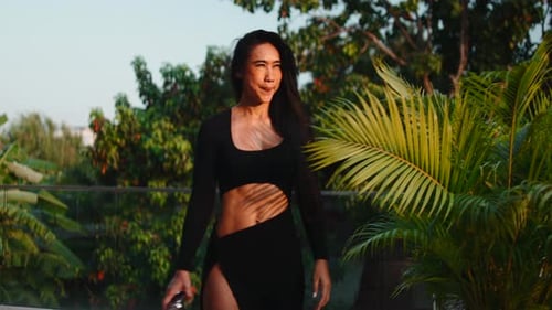 Empowered Athletic Woman Walking in a Tropical Garden