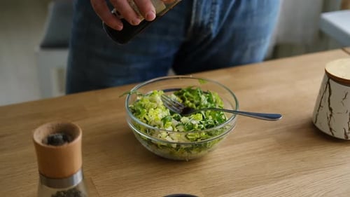 Handsome Bearded Man is Preparing Green Fresh Vegan Salad in the Kitchen at Home Male Cutting