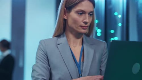 A Professional Woman in a Suit Showcases Her Tech Expertise in a Server Room