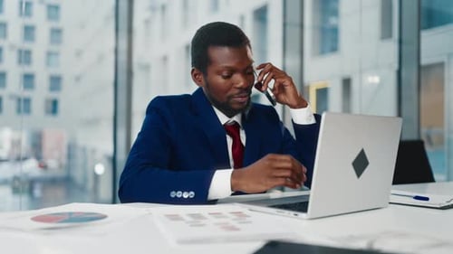Multitasking Businessman in Office Black Man Talking By Phone Typing on Laptop Professional of