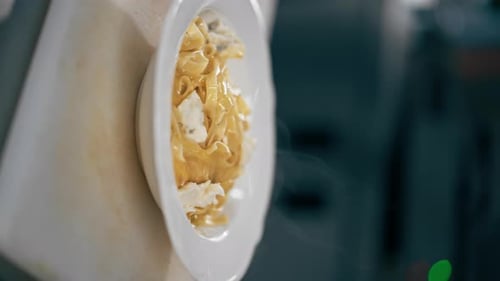 Pasta Dish Prepared with Cheese in Restaurant Setting