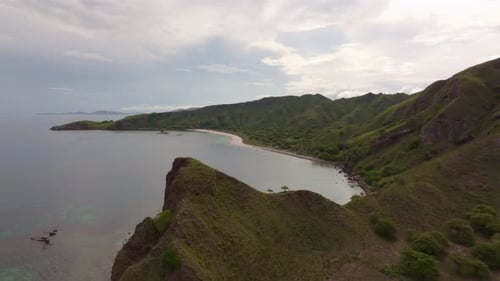Aerial view of tropical island beach with cliff coastline and ocean, Indonesia.