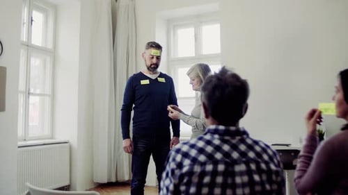 Un conseiller met des notes adhésives contenant des mots négatifs sur le client pendant la thérapie de groupe.