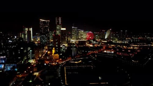 Nachtblick auf eine geschäftige Skyline der Stadt mit beleuchteten Gebäuden und einem Riesenrad