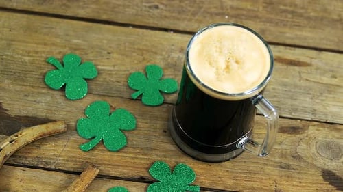Bird eye view of guinness pint, horse shoe and shamrocks on table for st patricks