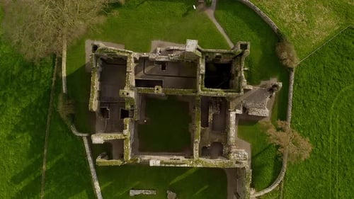 Aerial top down descends on Bective Abbey walls on sunny green Irish day, drone overview