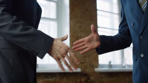 Businessmen Reach Agreement with Handshake in Modern Office