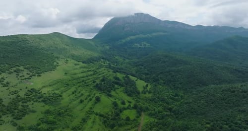 Belle et majestueuse formation rocheuse entourée de champs verts et de forêts