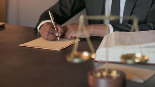 African Judge Writing Verdict in Court, Close Up