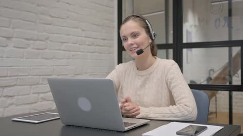 Woman on Laptop Video Call at Modern Office