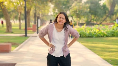 Woman Jogging Experiences Stomach Pain Outdoors