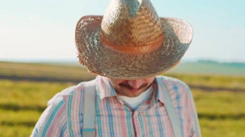 Portrait of Happy Male Caucasian Farmer Looking at the Camera with the Golden Wheat Field on the