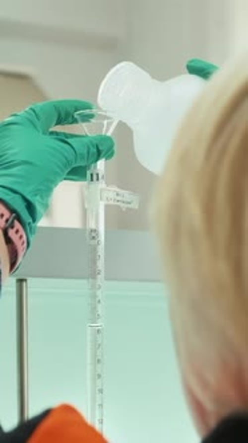 Chemists Mixing Up Solutions at the Lab Clip View Over the Shoulder of a Woman in Gloves Pouring