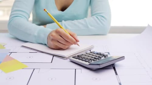 Woman Calculating and Writing About Home Plans