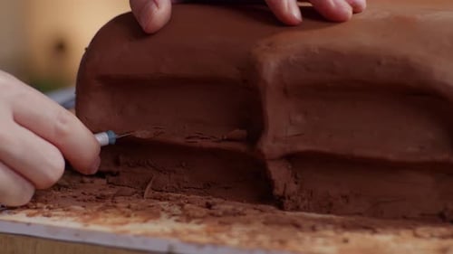 Designer's Hands Using Rake Or Wire To Create Details In The Sculpture Of Car Clay In The Studio