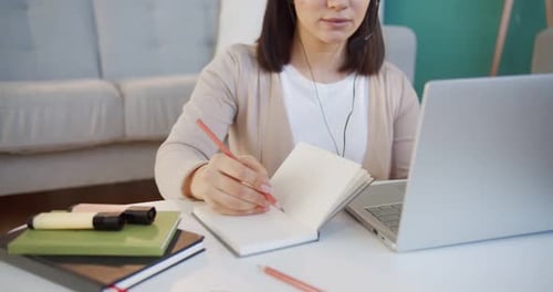 Woman Studying at Home with Laptop and Notebook
