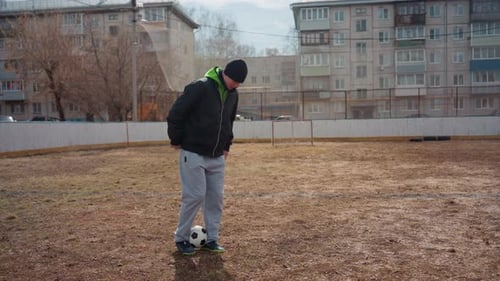 Urban Athlete Practicing Alone Male Freestyler Drills on Muddy Field Young Man Focuses on Freestyle