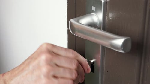 Hand Locking Up The Door With Key