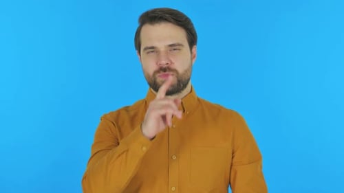 Man with Silence Gesture on Blue Background, Portrait