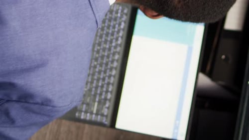 Adult Working on Laptop in Office