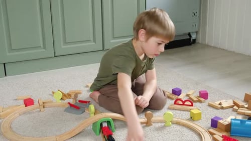 Boy Playing with Wooden Train Set at Home
