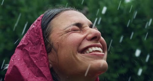 Woman Smiles While Getting Drenched in Rain