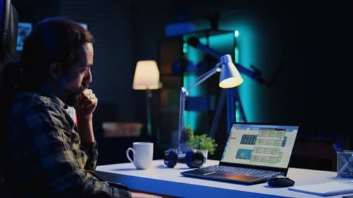 Man Working on Laptop at Night in Home Office