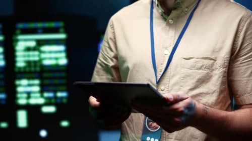 Adult Man Uses Tablet in Data Center