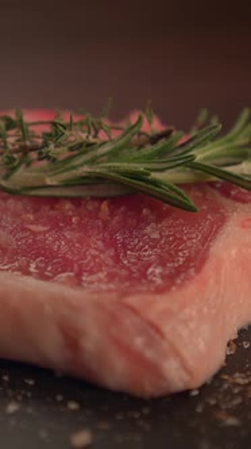 Raw Steak Topped with Rosemary, Ready to Cook